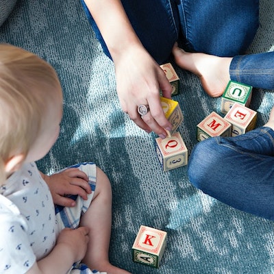 children sitting while looking at blocks